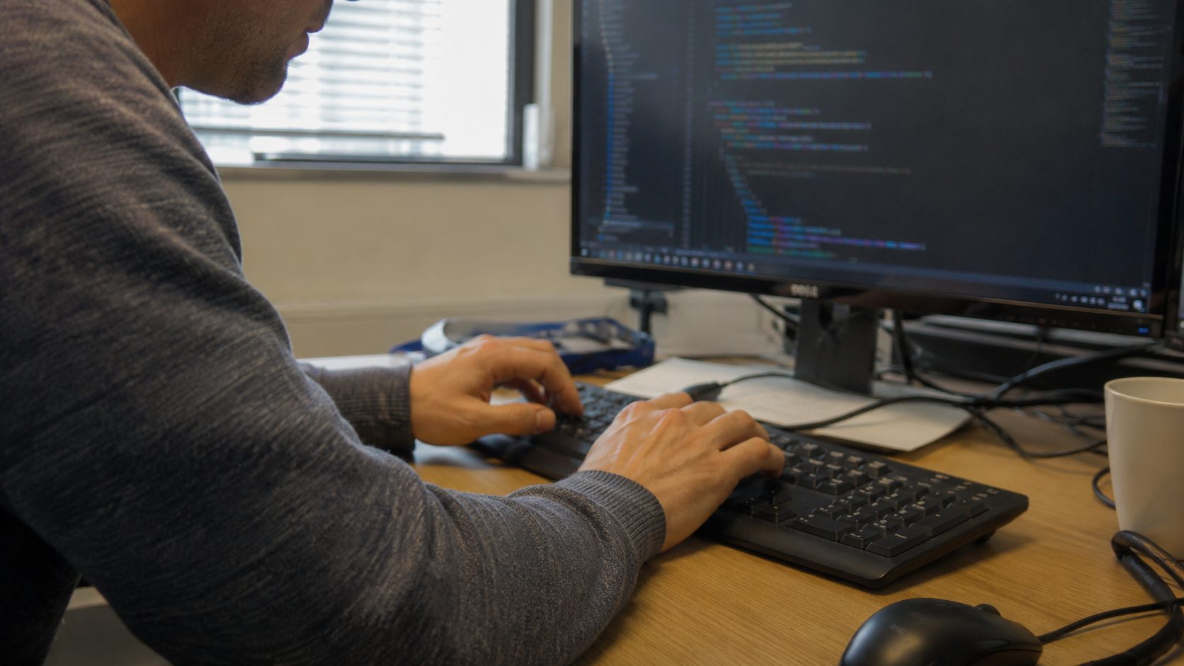 Intégrateur tapant un bloc de code JSON-LD sur un écran d'éditeur pour baliser une page web