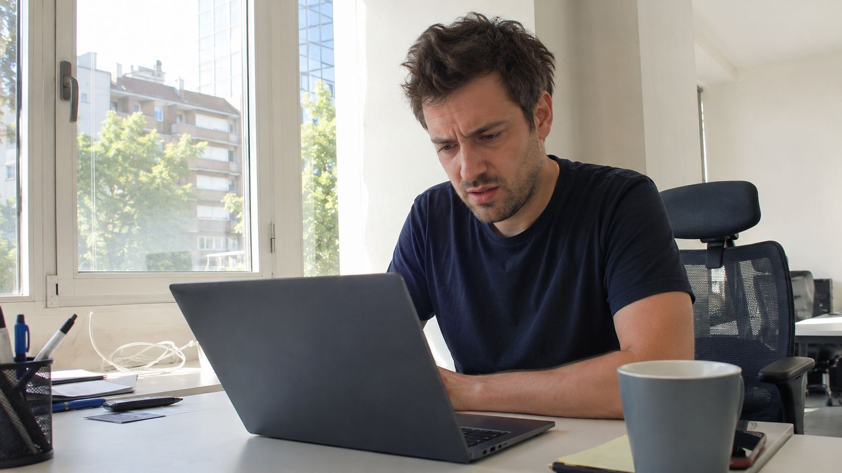 Dirigeant contrarié devant son ordinateur en constatant que sa production de contenu ne génère pas de trafic