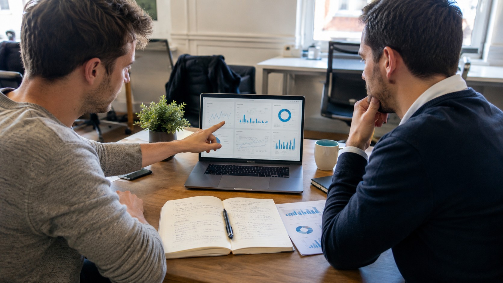 Consultant SEO et client analysant un tableau de bord de performances pour arbitrer une stratégie de référencement orientée résultats